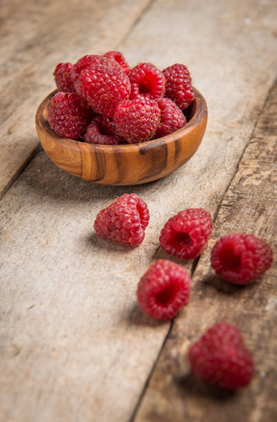 istock Fresh raspberries in wooden bowl on grey rustic wooden background 1031650366