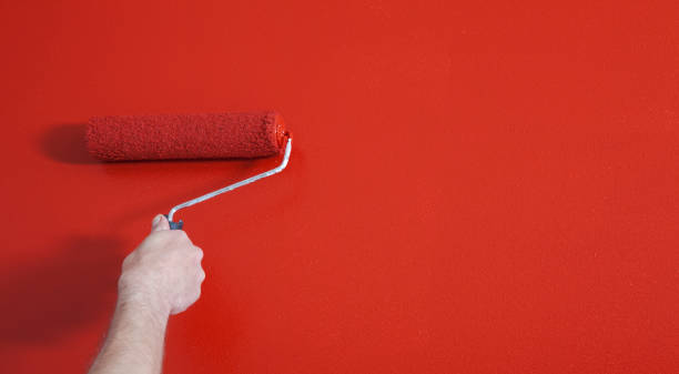 istock Person Painting a Wall Red with a Paint Roller 1031660020