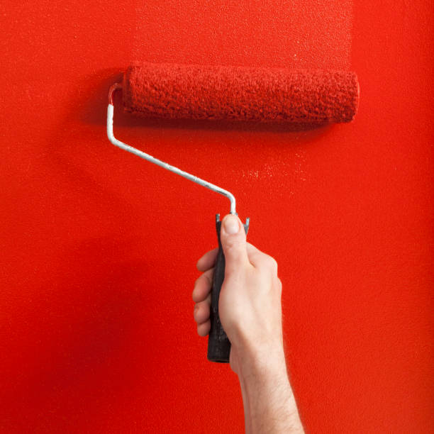 istock Person Painting a Wall Red with a Paint Roller 1031660038