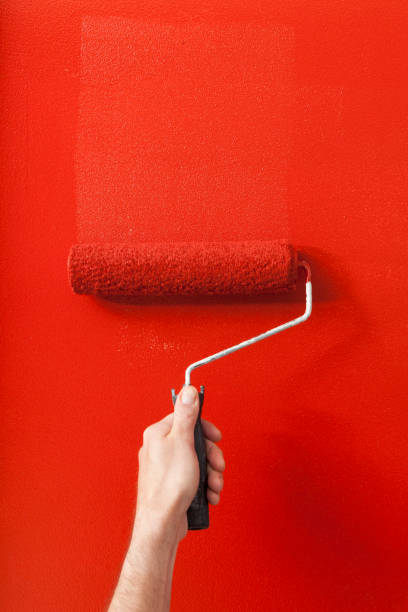 istock Person Painting a Wall Red with a Paint Roller 1031660114