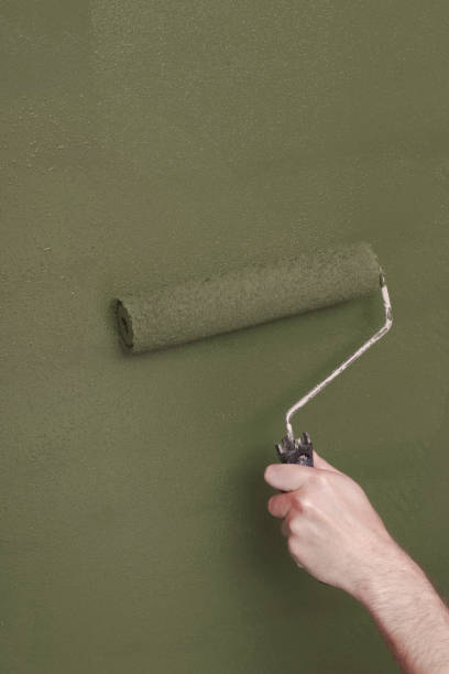 istock Person Painting a Wall Green with a Paint Roller 1031662252