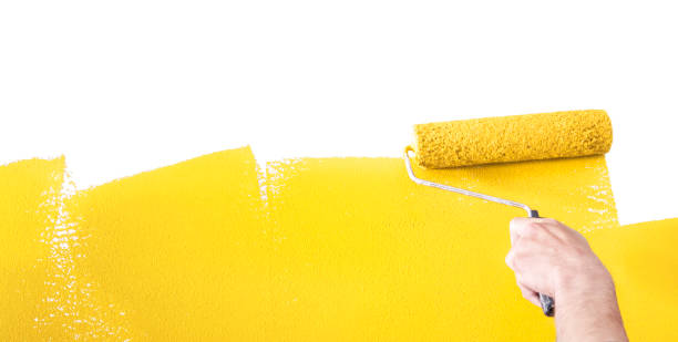 istock Person Painting a Wall Yellow with a Paint Roller 1031662436