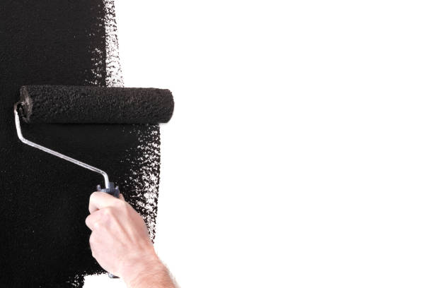 istock Person Painting a Wall Black with a Paint Roller 1031662456