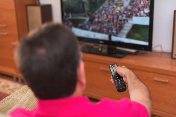 istock Back view of senior man watching tv holding remote control 1031663984