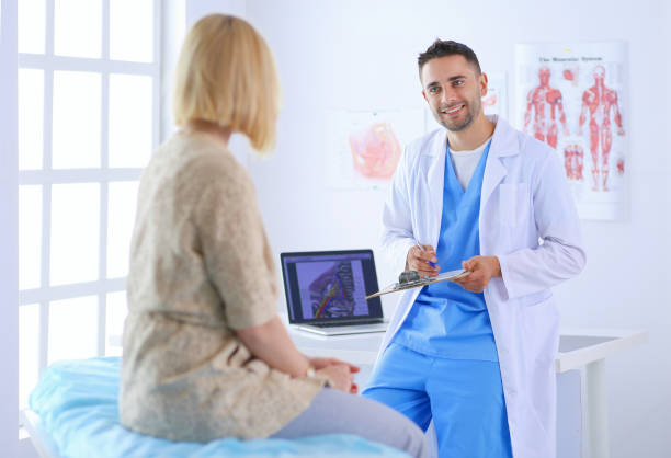 istock Handsome doctor is talking with young female patient and making notes while sitting in his office 1031669230