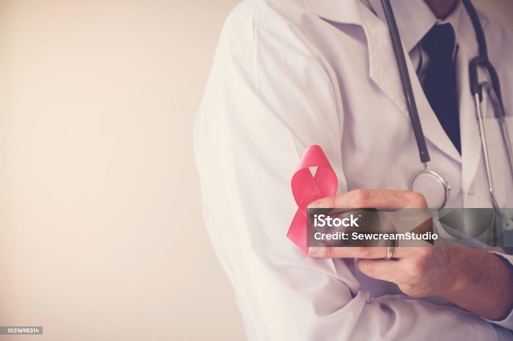 Doctor holding pink ribbon, breast cancer awareness, October pink concept Breast Cancer Stock Photo