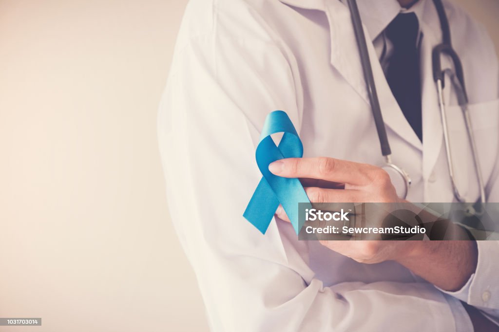 Doctor hands holding Light blue ribbon,  Prostate Cancer Awareness November Stock Photo