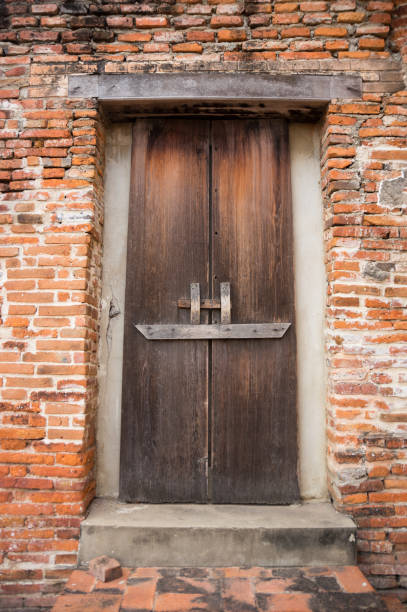 istock Ancient wooden door on brick wall. 1031705900