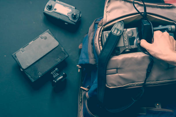 istock overhead top view of hands put camera accessories in the bag on a dark surface 1031719418
