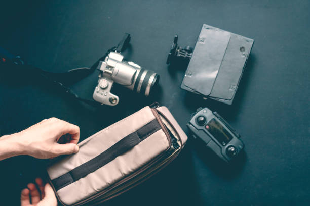 istock overhead top view of hand put camera accessories in bag on dark background 1031719456