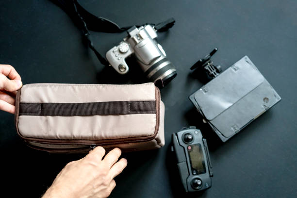 istock overhead top view of hand put camera accessories in bag on dark background 1031719462