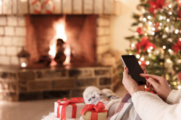 暖炉のそばで座っている女性 - ipad shopping gift retail ストックフォトと画像