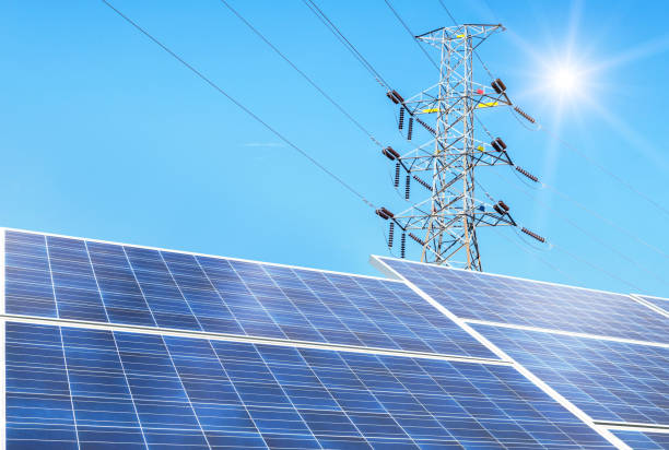 istock Rows array of polycrystalline silicon solar cells or photovoltaics in solar power plant with  high voltage electric pylon pillar substation 1031725472