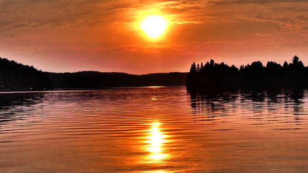istock Sunset over the water lined with mountains and fir trees 1031739878