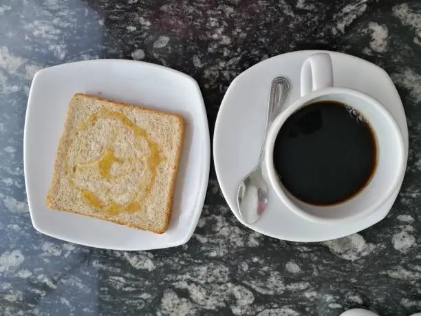 cup of black coffee, hot coffe and piece of roasted bread with honey toast