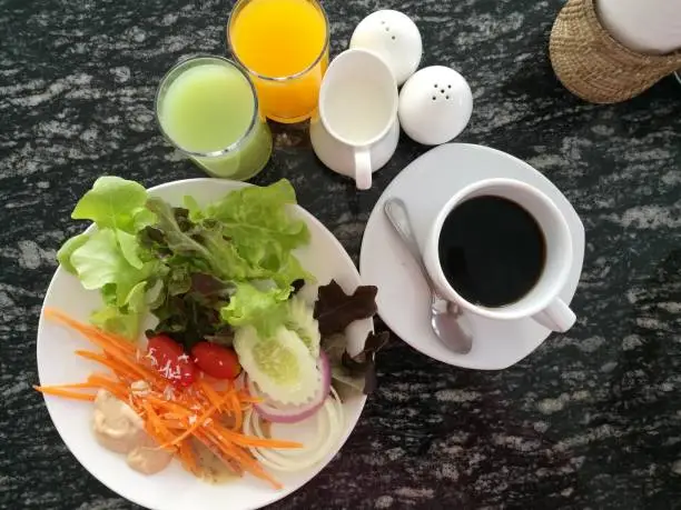 cup of black coffee, hot coffe. organic fresh salad with orange juice and guava juicy. breakfast set for healthy.