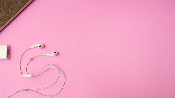 istock Earphones and notebook on pink  background. Pastel color Minimal concept Copy space 1031759822