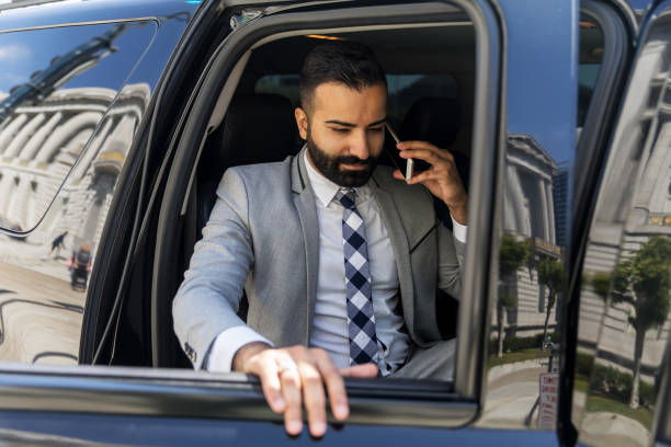 istock Businessman Using Smart Phone in a Limousine 1031760092