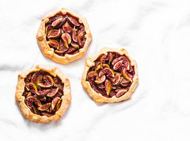 istock Caramelized figs tarts or pies on a light background, top view. Flat lay 1031780970