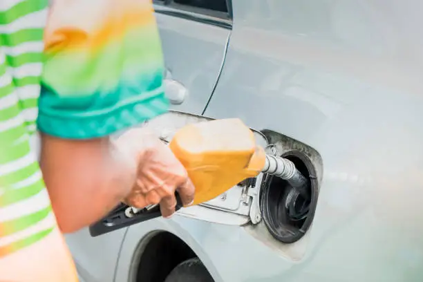 Photo of Man filling gasoline oil in car holding nozzle
