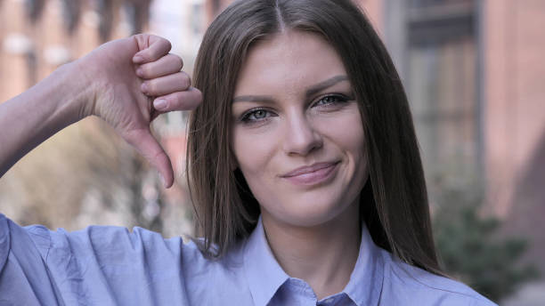 istock Thumbs Down by Young Woman at Work,  Looking at Camera 1031814532