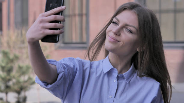 istock Woman Outside Office Taking Selfie on Smartphone 1031816682