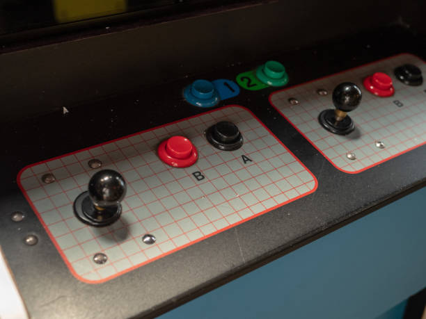 Joystick and button controls of classic arcade cabinet in dark arcade