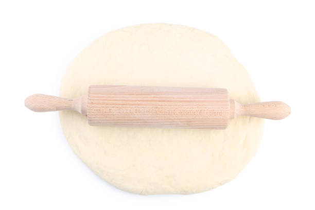 istock Raw dough with rolling pin isolated on white background 1031825336