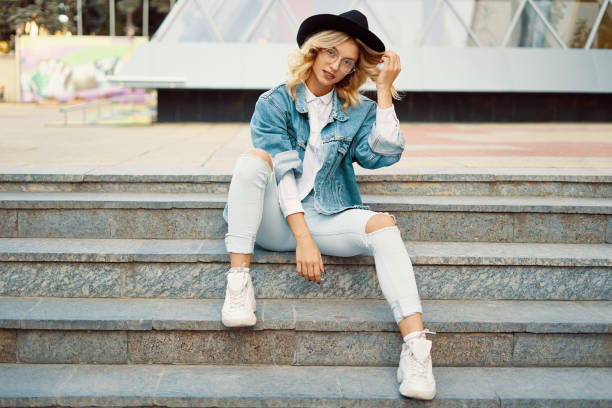 istock Modern hipster girl posing while sitting on stairs on urban back 1031843886