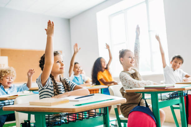 istock group of schoolchildren raising hands to answer question during lesson 1031844720