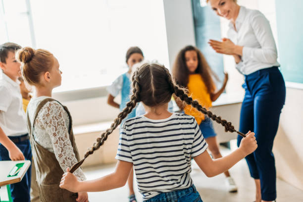 istock group of multiethnic classmates standing around teacher at classroom 1031844728