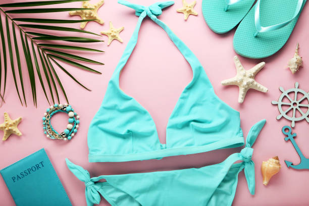 istock Blue swimsuit with palm leaf and starfishes on pink background 1031848856