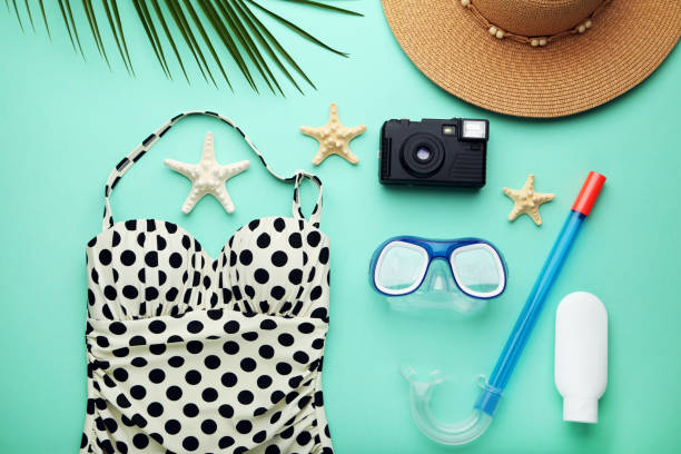 istock Swimsuit with starfishes and cosmetic bottle on mint background 1031849744