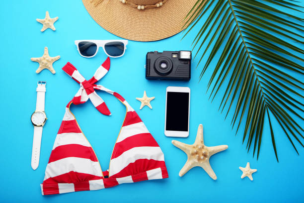 istock Swimsuit with green palm leaf and accessories on blue background 1031849966