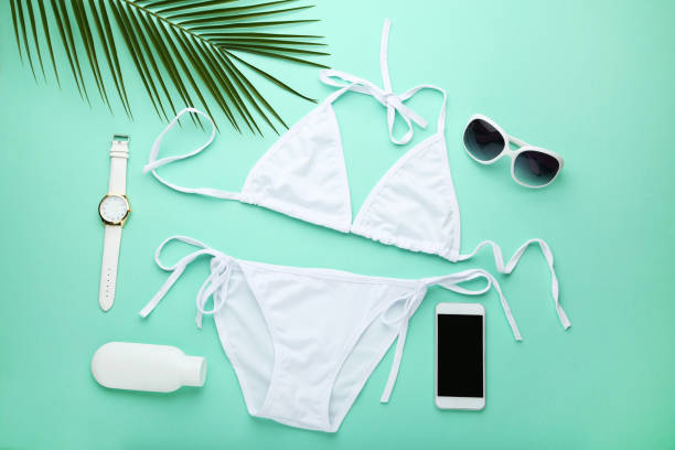 istock White swimsuit with palm leaf and accessories on mint background 1031852638