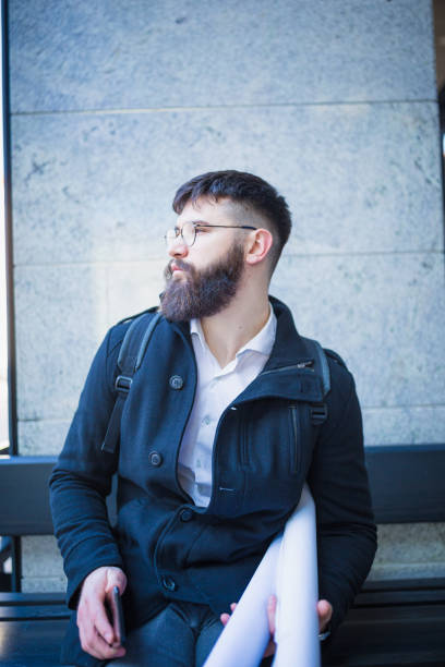 istock Young hipster architect, using mobile phone on his way to the office 1031856112