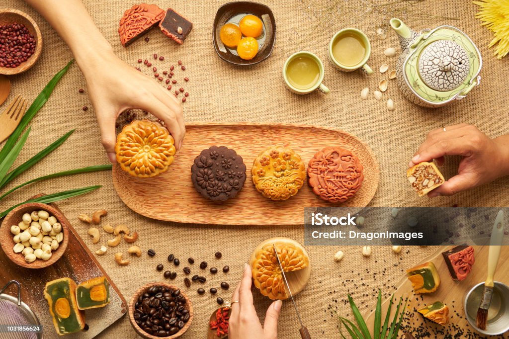 Teats for mid autumn festival Hands of people eating tasty round moon cakes at mid autumn festival Moon Cake Stock Photo
