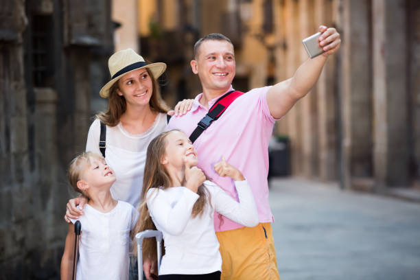 istock Ordinary parents with two kids taking selfie 1031859144