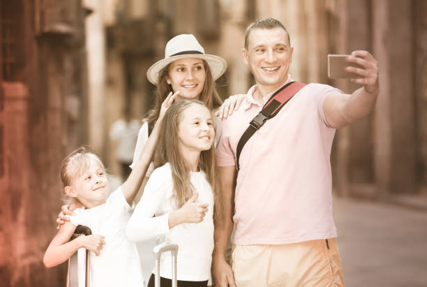 istock Smiling parents with two kids taking selfie 1031859372