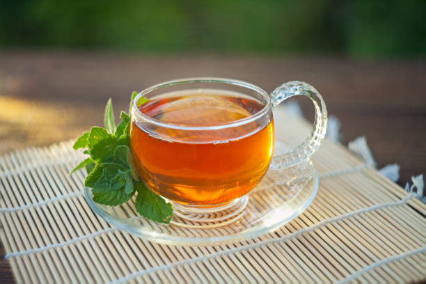 delizioso tè verde in una bella ciotola di vetro sul tavolo - lavender mint tea foto e immagini stock