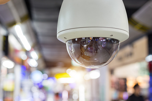 Close-up of surveillance camera in underground parking space.