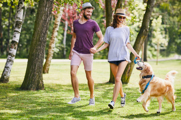 istock Young couple running and playing with their dog while out on a walk 1031860722