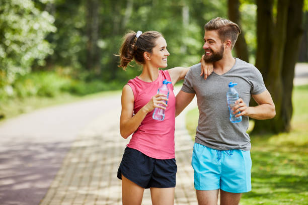 istock Young couple taking break while joging and embracing in the park 1031860918