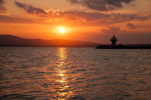istock Lighthouse against a beautiful evening sunset on the sea. 1031863496