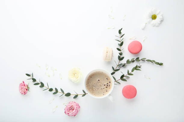 istock Flowers with cup of coffee and macaroons on white background 1031863900
