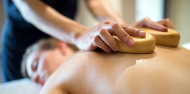 istock Masseur massaging masseuse at wellness resort 1031864416