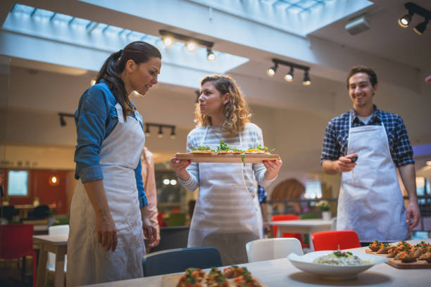 istock Attendees of cooking class serving their prepared food for Chef 1031866862