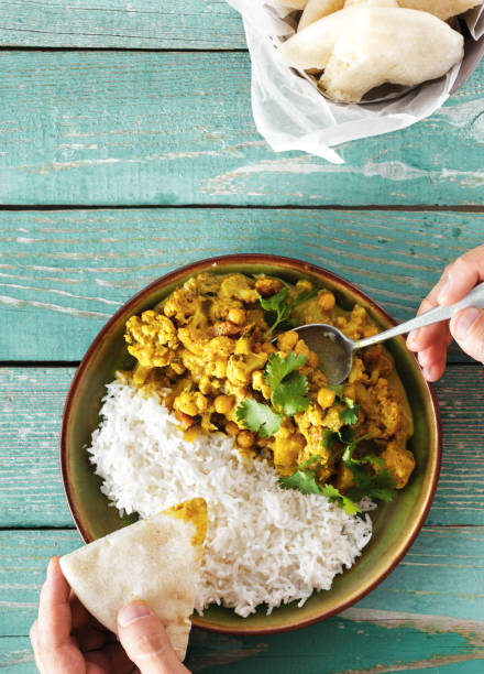 istock Man is eating cauliflower spicy curry with rice and naan bread 1031868008
