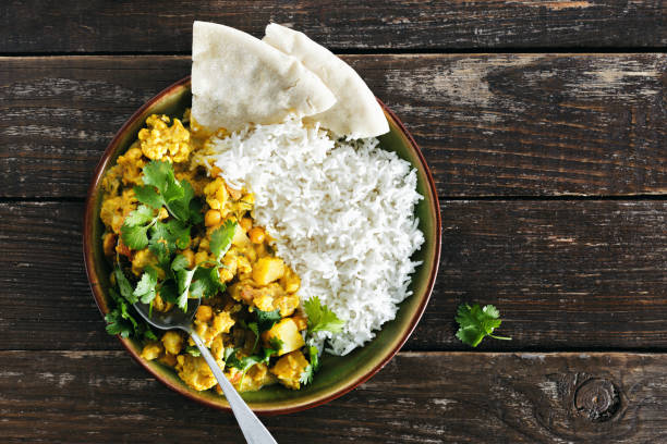 istock Cauliflower spicy curry with rice and naan bread top view 1031870392