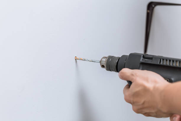 istock home renovation closeup hand using drill to drilling bit hole on the wall to install floating shelves 1031870474